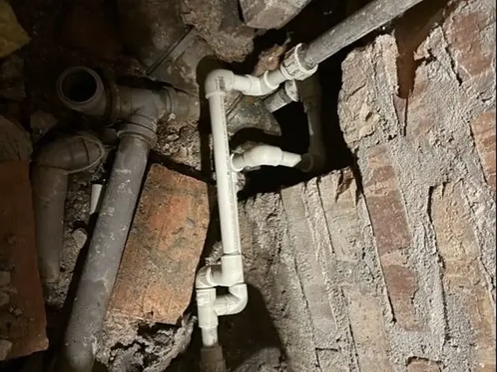 Stare rury żeliwne w ceglanej ścianie — DobryHydraulik Katowice