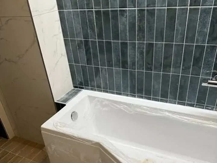 Nowa wanna przy granatowych płytkach — DobryHydraulik Katowice